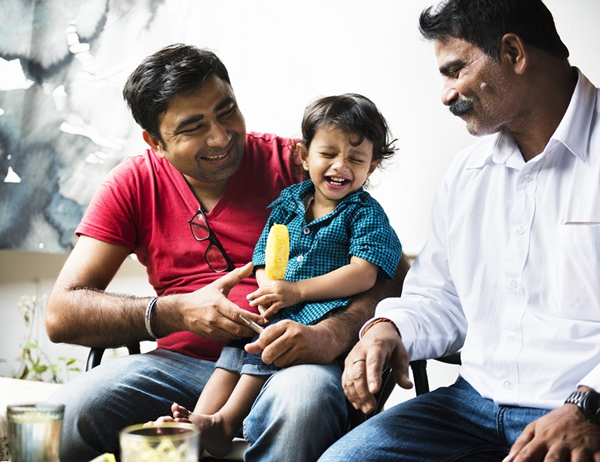 happy Indian family with child father, son and grandfather sitting together laughing